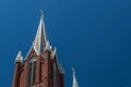 Gothic revival church steeples with crosses, very sunny day, blue sky