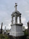 In a gothic scene, a cemetery monument stands tall, with a pillar and temple nearby