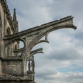Gothic-style flying buttresses extend from a stone cathedral wall, showcasing Royalty Free Stock Photo