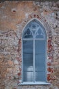 Gothic window in an old shabby brick wall. Royalty Free Stock Photo