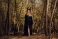 Gothic young girl with the Maleficent horns and a black cape  in forest Royalty Free Stock Photo