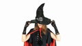 Gothic young woman in witch halloween costume with hat standing over white background. Beautiful young girl in black dress, Royalty Free Stock Photo