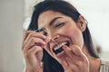 Gotta clean in between as well. Portrait of an attractive young woman flossing her teeth at home. Royalty Free Stock Photo