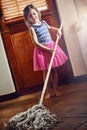 Gotta keep the house sparkling clean. a little girl mopping the floor at home. Royalty Free Stock Photo