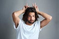 Gotta make room for a little goofiness. Studio portrait of a young man showing a bunny ears gesture against a grey Royalty Free Stock Photo