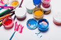 Gouache paint, brushes, and colored pencils on a light background Royalty Free Stock Photo