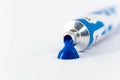 Gouache tube dripping blue paint and white background Royalty Free Stock Photo