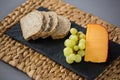 Gouda cheese, bread slices and grapes on slate plate Royalty Free Stock Photo