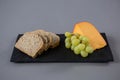 Gouda cheese, grapes and brown bread slices on slate plate Royalty Free Stock Photo