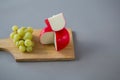 Gouda cheese with grapes on chopping board Royalty Free Stock Photo