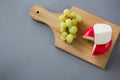 Gouda cheese with grapes on chopping board Royalty Free Stock Photo