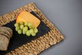 Gouda cheese and grapes on slate plate Royalty Free Stock Photo