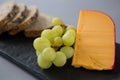 Gouda cheese and grapes on slate plate Royalty Free Stock Photo