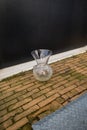 Gouda, South Holland/the Netherlands - March 1 2020: Glass transparant vase on the floor in between carbage containers left behind