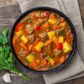 Goulash, beef stew or bogrash soup with meat, vegetables and spices in cast iron pan.