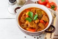 Goulash in ceramic bowl on white wooden background. Traditional hungarian soup. Royalty Free Stock Photo