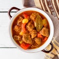 Goulash in ceramic bowl on white wooden background. Traditional hungarian soup. Royalty Free Stock Photo