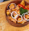 Goulash from chicken pieces and vegetables, served with greens, red pepper and onion rings according Royalty Free Stock Photo