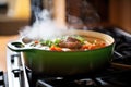 goulash simmering in cast-iron pot, steam visible