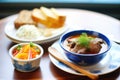 goulash soup served with a side of fresh bread rolls