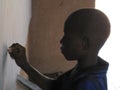 Unidentified child writing on blackboard in charity run school, Burkina Faso