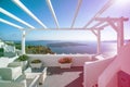 Gourgeous balcony view in white walled resort in Santorini, Greece, with ocean and cliffs in the background. Colored Royalty Free Stock Photo