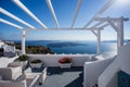 Gourgeous balcony view in white walled resort in Santorini, Greece, with ocean and cliffs in the background