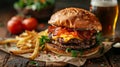 Gourmet bacon cheeseburger with sesame bun, served with fries and beer Royalty Free Stock Photo