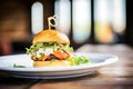 gourmet burger with arugula and goat cheese on a brioche bun