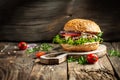 Gourmet burger with blue cheese and arugula on rustic wooden background. fast food and junk food concept Royalty Free Stock Photo