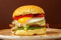 Gourmet burger featuring a juicy beef patty topped with egg, crispy bacon. Royalty Free Stock Photo