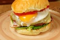 Gourmet Burger With Fried Egg and Bacon, ready to be enjoyed. Royalty Free Stock Photo