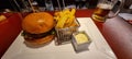 Gourmet burger and fries with beer on table Royalty Free Stock Photo