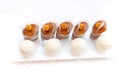 Caramel nut desserts in cups and coconut candies on a plate