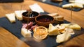 Gourmet charcuterie ceramic stone board with assorted cheeses, dried fruits, strawberries, pears, sliced bread, cured Royalty Free Stock Photo