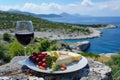 Gourmet Cheese Platter with Plavac Mali Red Wine Overlooking a Serene Mediterranean Seascape Royalty Free Stock Photo