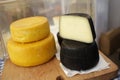 Gourmet cheese. Yellow goat cheese and cheese in a sepia ink wrap. Delicatessen cheeses. Delicious cheese. Farm made organic. Royalty Free Stock Photo