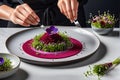 Gourmet Chef Plating an Intricate Dish: Arranging a Delicate Microgreen Salad Atop a Spiral of Ruby Elegance Royalty Free Stock Photo