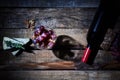 Gourmet composition of wineglass with grapes and walnuts on wood table with cheese and bottle of red wine