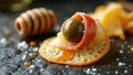 Gourmet cracker appetizer with olive, prosciutto, cheese, and honey drizzle Royalty Free Stock Photo