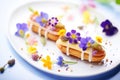 gourmet eclairs with edible flowers, soft backlight