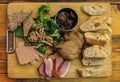 Gourmet platter with duck pate, foie gras, duck confit and seared duck breast on a wooden cutting board in a restaurant