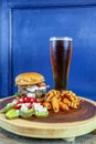 Gourmet Grilled burger with bacon and gorgonzola cheese on a brioche bun with beer Royalty Free Stock Photo