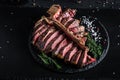 Gourmet grilled and sliced porterhouse steak T-bone with herbs and spices. American meat restaurant served on slate board. banner Royalty Free Stock Photo