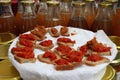 Gourmet mini bites of spelled bread with pesto of basil and olives and garden tomatoes on a white plate on a farmers market