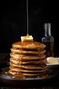 Gourmet photography of stack of browned delicious pancakes with maple syrups and butter over dark background