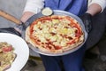 Gourmet pizza with barbeque sauce, grilled chicken, cheese served by waiter in restaurant or diner Royalty Free Stock Photo