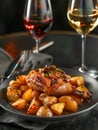 Gourmet Roasted Chicken Leg with Herbed Potatoes and White and Red Wine in Elegant Setting