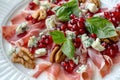 Gourmet salad with prosciutto, pomegranate, blue cheese, and walnuts