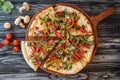 gourmet sliced pizza with vegetables and meat on wooden